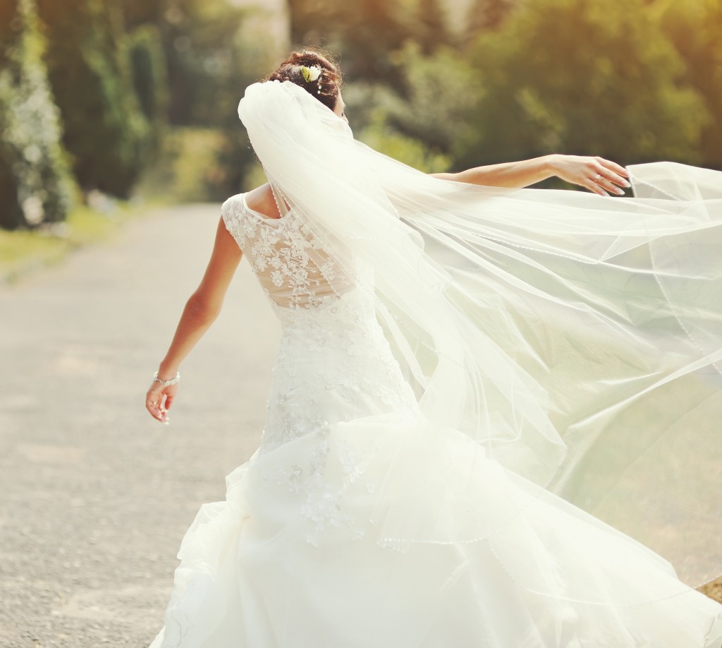 Happy bride spinning around with veil