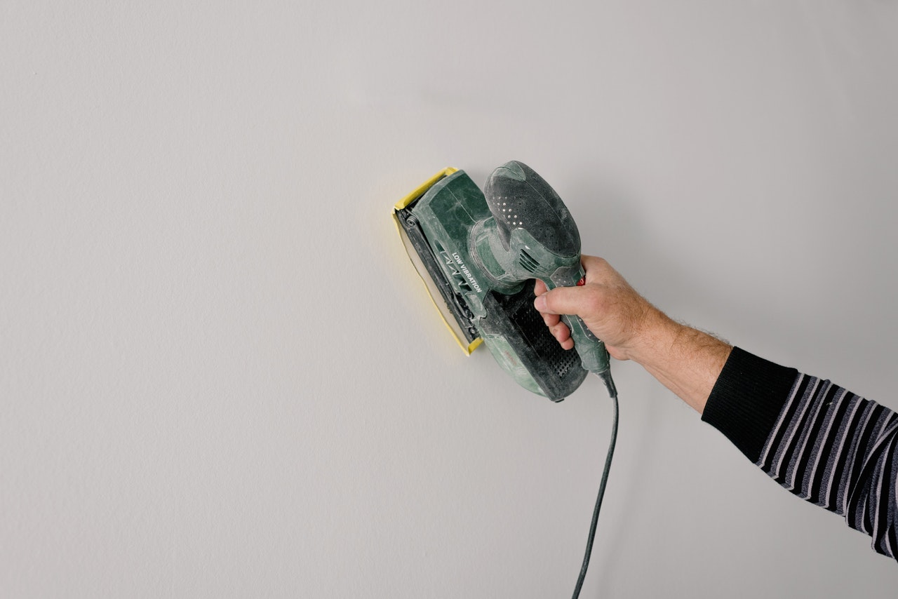 person polishing the dry wall