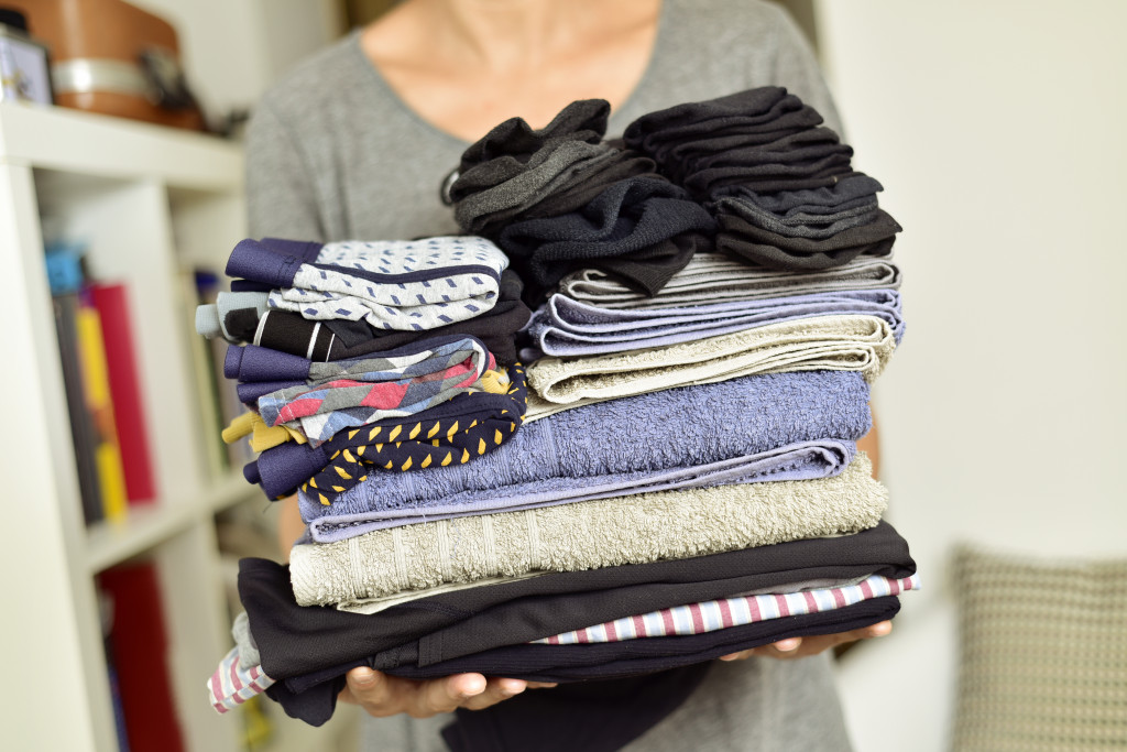 woman carrying folded clothes