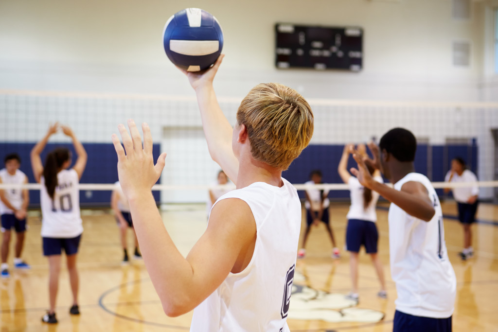 High schoolers playing volleyball in the gymnasium