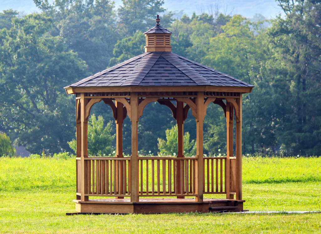 a wooden gazebo in a field