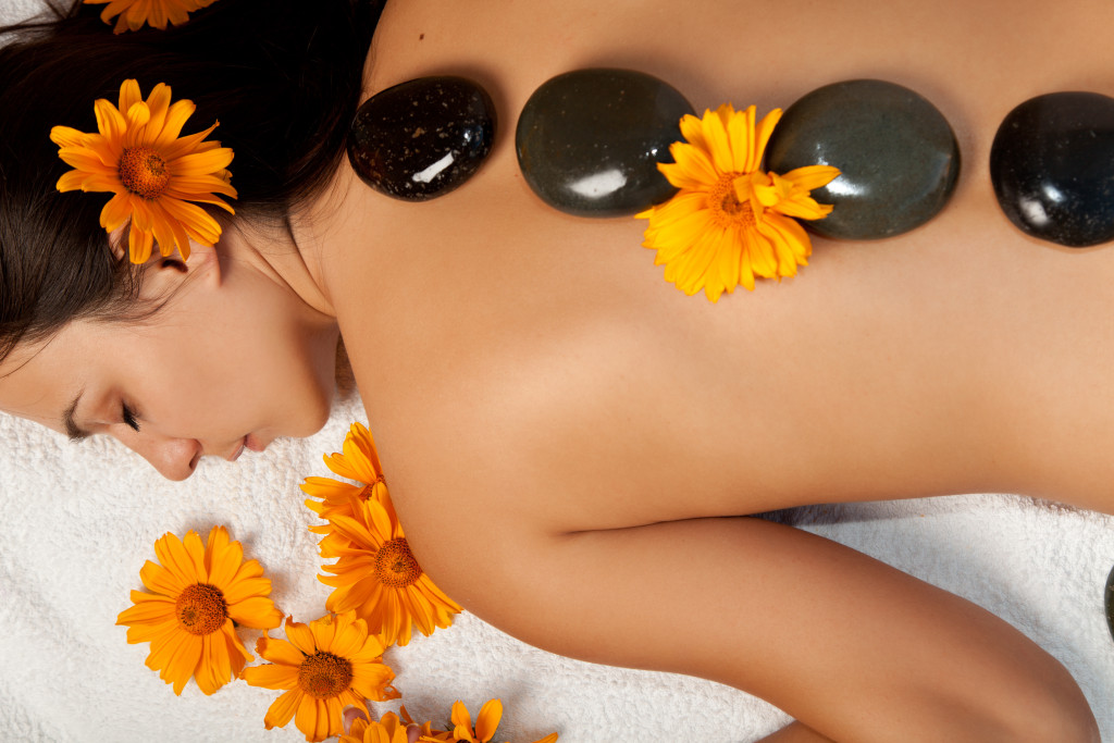 Woman getting a hot stone massage at a spa salon.