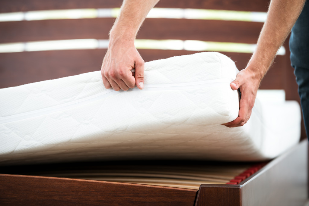 arms of a man lifting the mattress