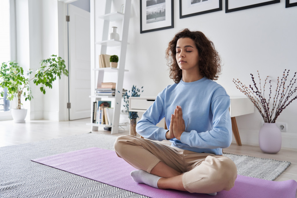 A woman in her living room doing meditation