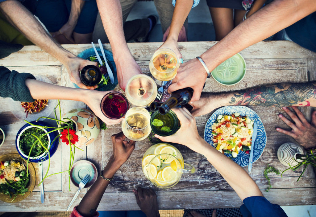 People doing a toast with various drinks outdoors