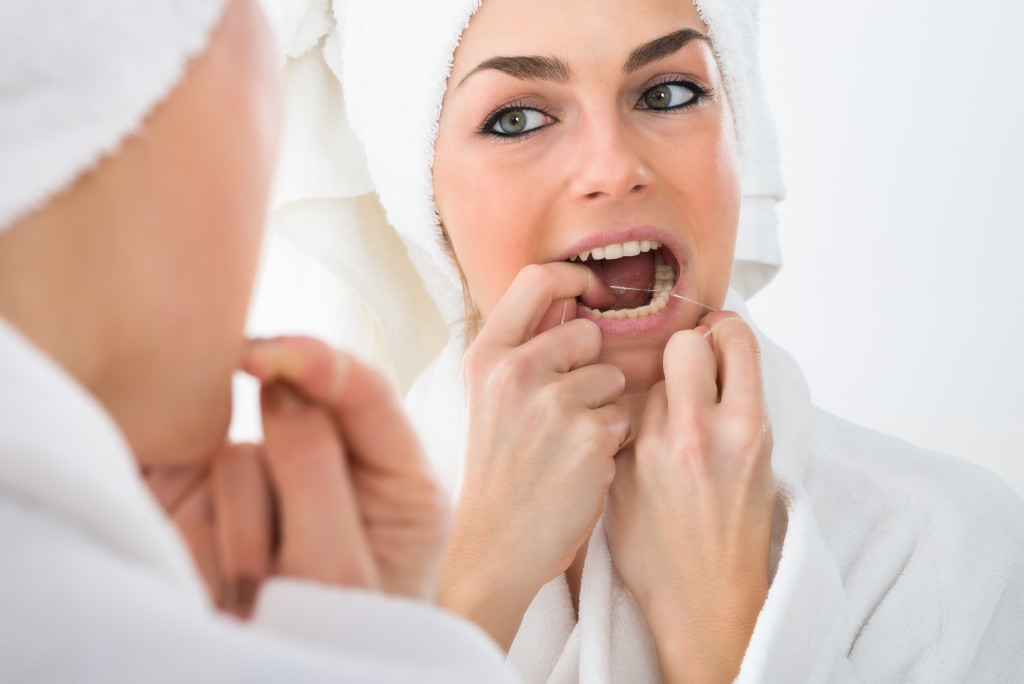 A woman flossing her teeth