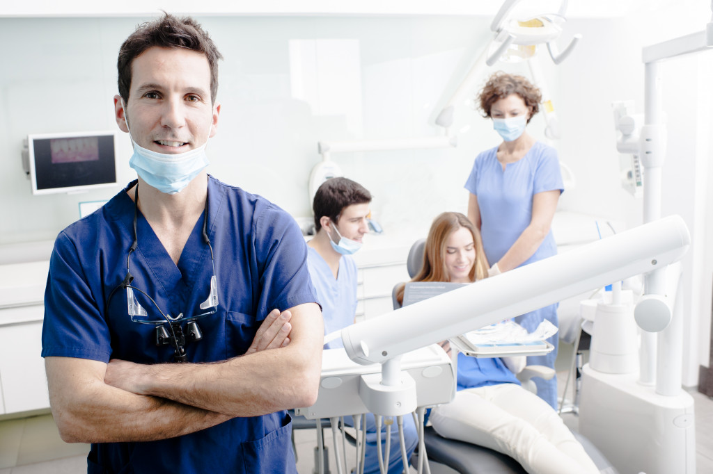 A dentist and his team checking on a patient