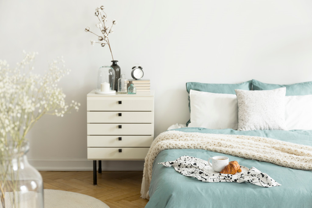 soft textures on minimalist bedroom with mint green blanket and pillows