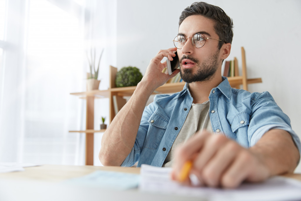 A man looking serious while talking over the phone