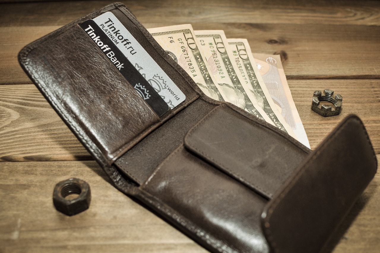 a brown wallet with dollar bills