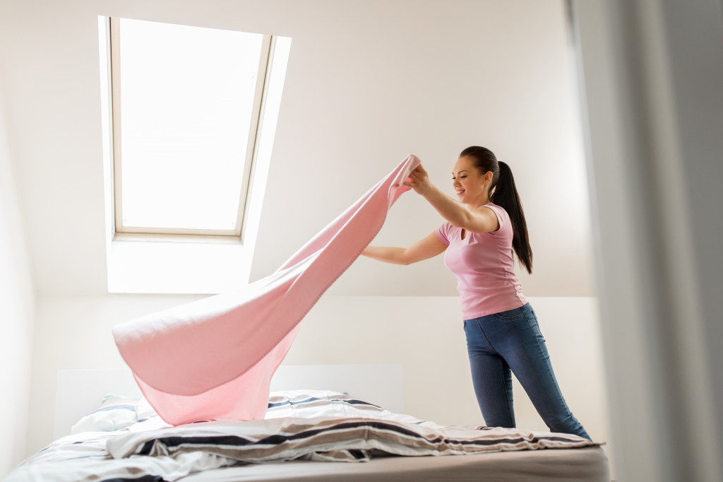 woman organizing bed in the morning