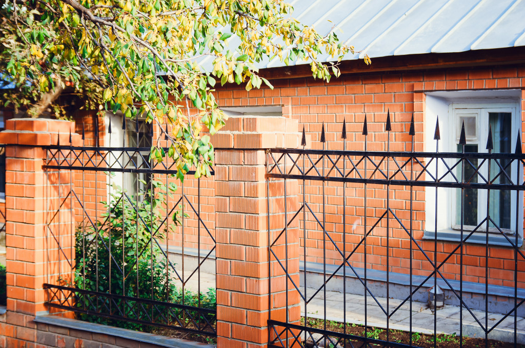 A black metal fence on brick columns