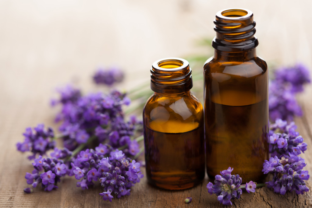 Lavender buds around bottles of essential oils