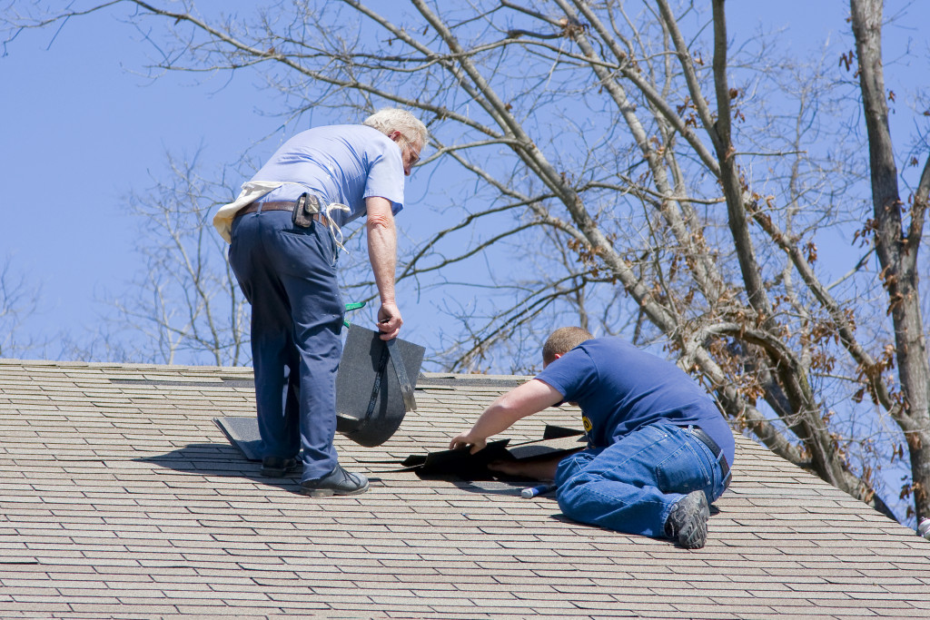 repairmen checking roof of a house