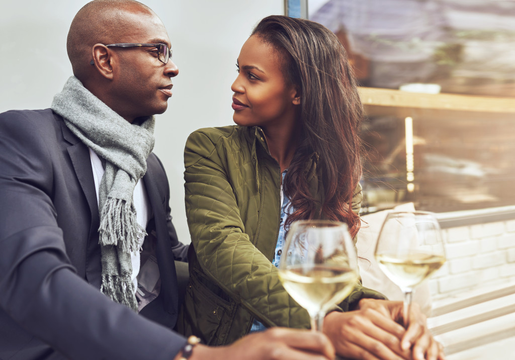 A couple drinking white wine outdoors in a cafe