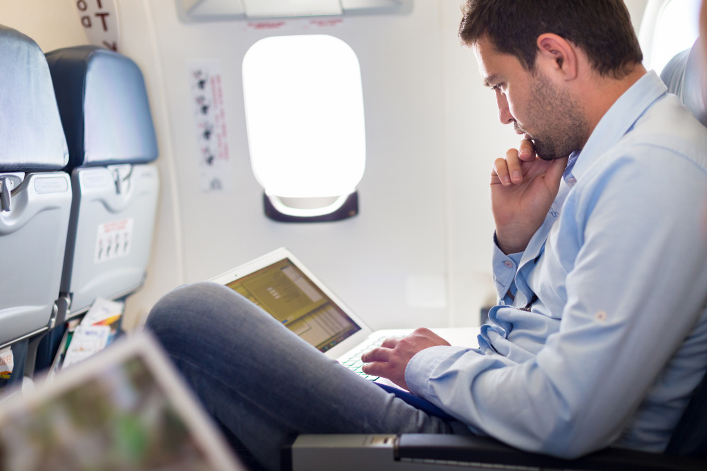 man sitting while being busy on his laptop