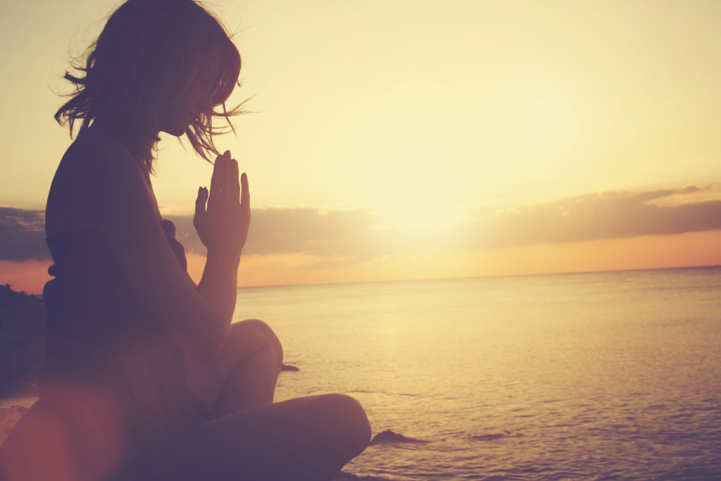 A woman meditating near the sea