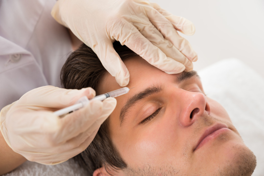 A handsome man getting a Botox injection in a clinic